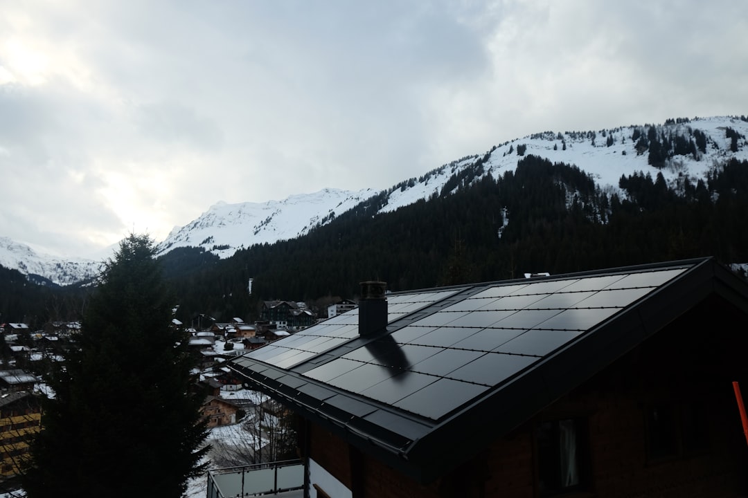 Photovoltaikanlage auf Hausdach im Winter mit Schnee und Sonne