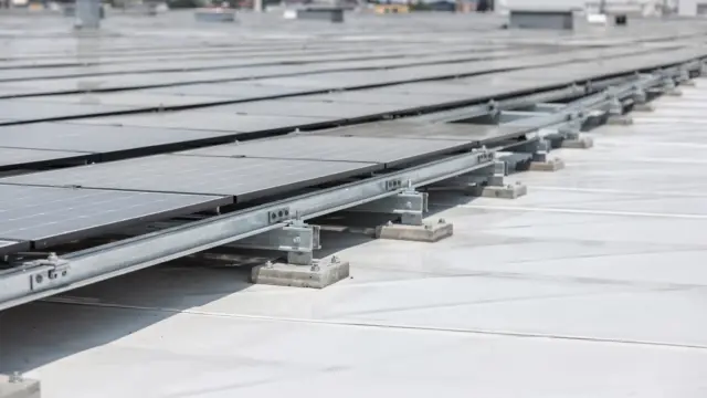 Bifaziales Solarmodul auf einem Flachdach mit hellem Untergrund, das Licht von Vorder- und Rückseite nutzt