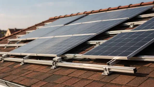 Solarmodule auf einem geneigten Hausdach mit Montageschienen und Dachhaken bei einer Aufdachanlage.